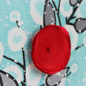 Close up of gray leaves on aqua background of painting on mini canvas with red 3d flower