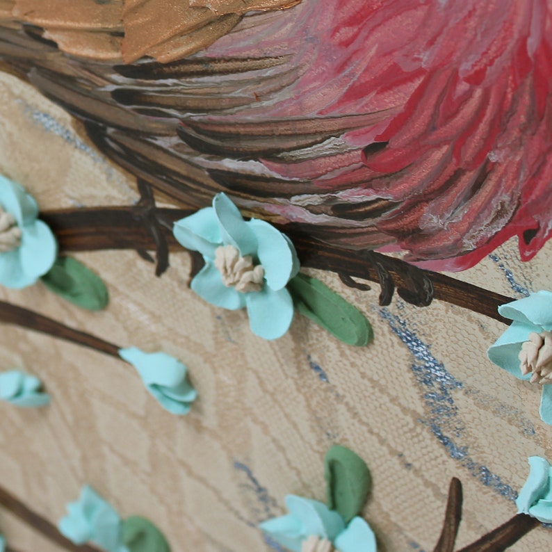 Close up of red feathers on painting of finch bird with impasto textured copper feathers on a robins egg blue flowering branch