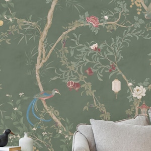 May include: Green wallpaper featuring a detailed botanical design with branches, flowers, and birds. The artwork includes a variety of blossoms, pomegranates, and a bird with blue tail feathers. The background is a muted green.
