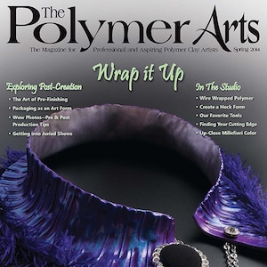 Puede incluir: Un collar de arcilla polimérica morado con un borde de flecos y una cadena plateada. El collar tiene un botón grande, redondo y negro con un adorno plateado y de cristal. El texto de la portada de la revista dice "Polymer Arts" y "Wrap it Up".