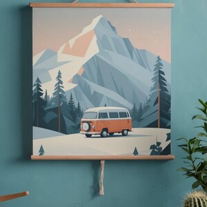 May include: A framed print featuring an orange and white camper van parked in a snowy landscape with a mountain backdrop. The artwork has a minimalist style with a color palette of blues, oranges, and whites.