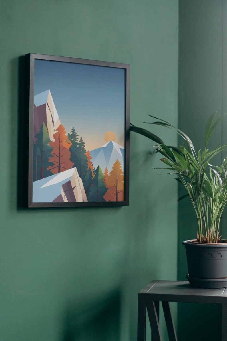 May include: A framed art print depicting a mountain landscape with a sunset. The artwork features geometric shapes and a color palette of blue, orange, and green. The frame is black, and the print is hanging on a green wall.