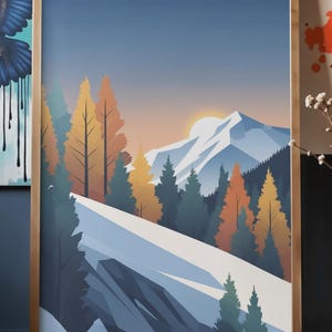 May include: A framed art print featuring a stylized mountain landscape. The artwork depicts a snow-covered mountain range, evergreen and autumn-colored trees, and a setting sun against a blue sky. The frame is made of wood.