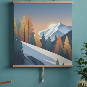 May include: A landscape art print featuring a mountain scene with a sunset. The artwork showcases a snow-covered mountain, evergreen and autumn-colored trees, and a setting sun. The print is displayed with wooden bars and a hanging cord.