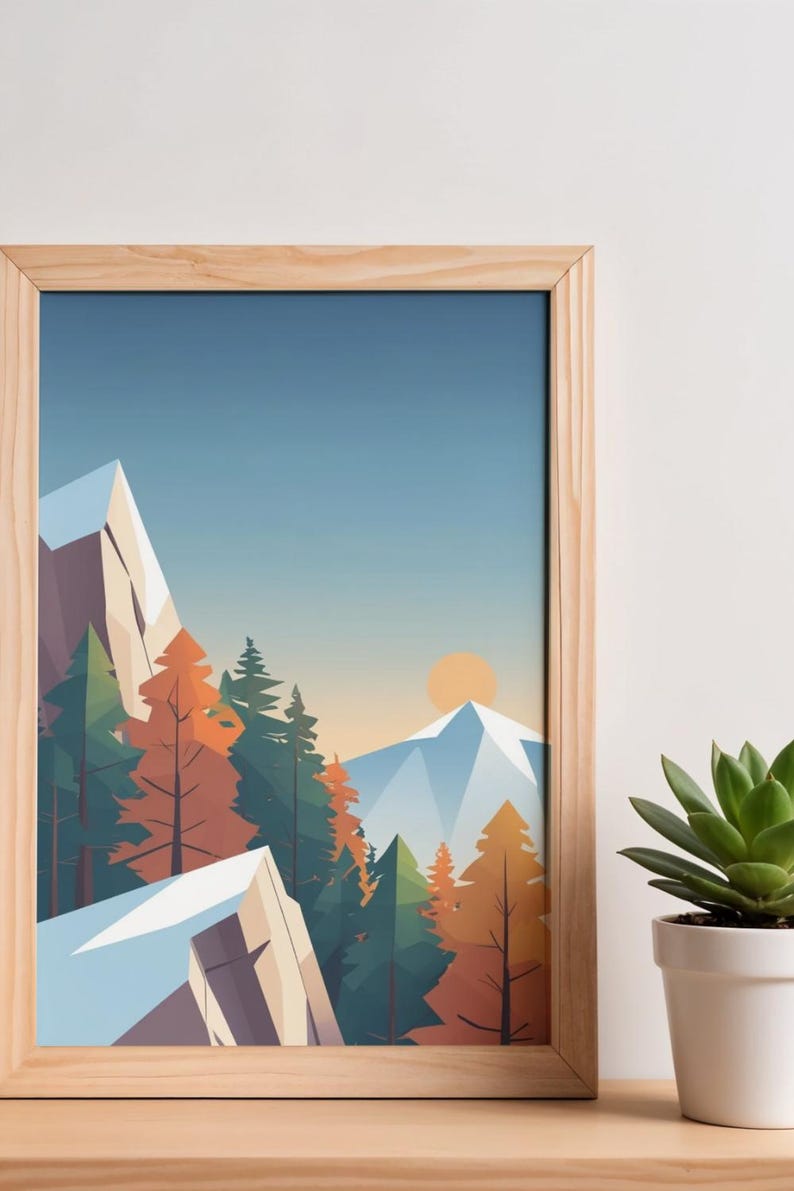 May include: A framed art print featuring a stylized mountain landscape. The artwork depicts snow-capped mountains, evergreen and autumn-colored trees, and a setting sun against a blue sky. The frame is made of light-colored wood.