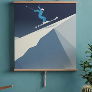 May include: A framed print featuring a skier in a blue jumpsuit and white helmet, mid-air on a snowy mountain slope. The artwork uses a minimalist style with shades of blue and white, mounted on wooden bars.