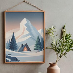 May include: A framed print of a winter scene, showing a cabin, snow, and mountains. The artwork features a cabin with a lit fireplace, evergreen trees, and a large mountain in the background. The frame is made of light-coloured wood.