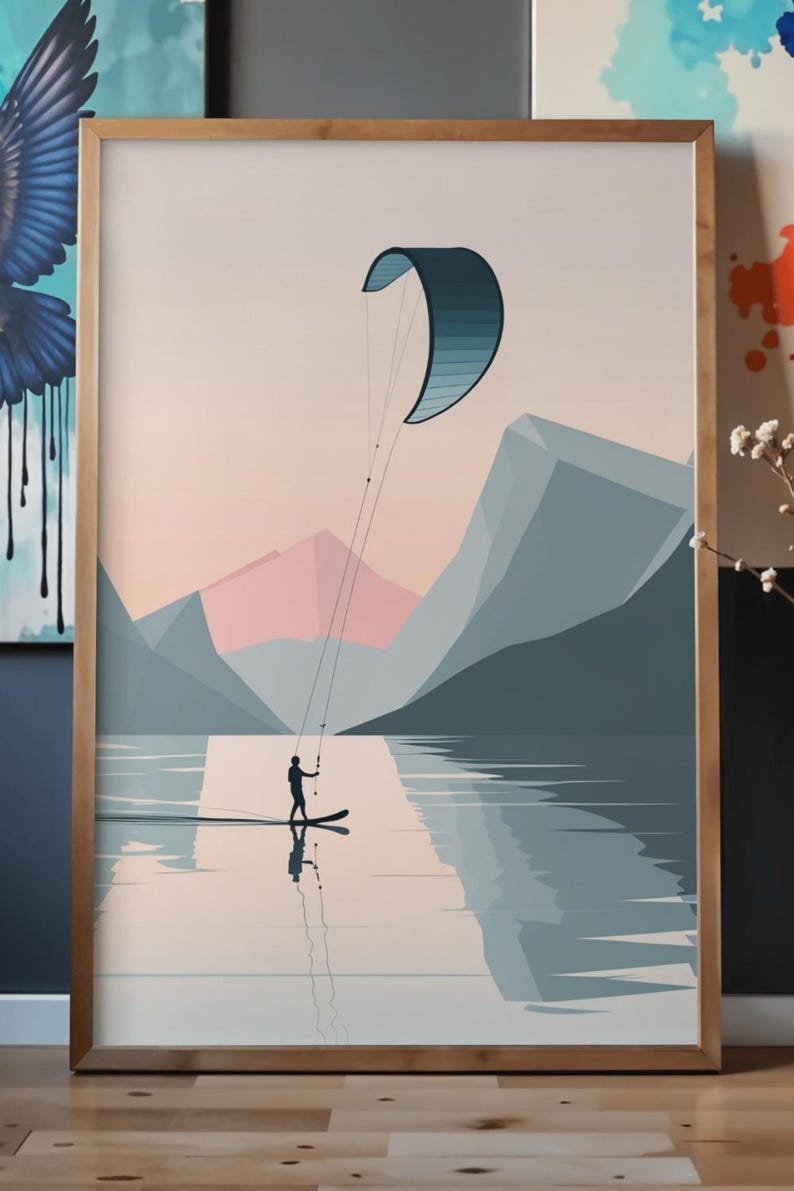 May include: Framed art print featuring a watersports scene. A person is kitesurfing on a lake, with a blue and teal kite against a backdrop of mountains and a pastel sky. The artwork is in a wooden frame.