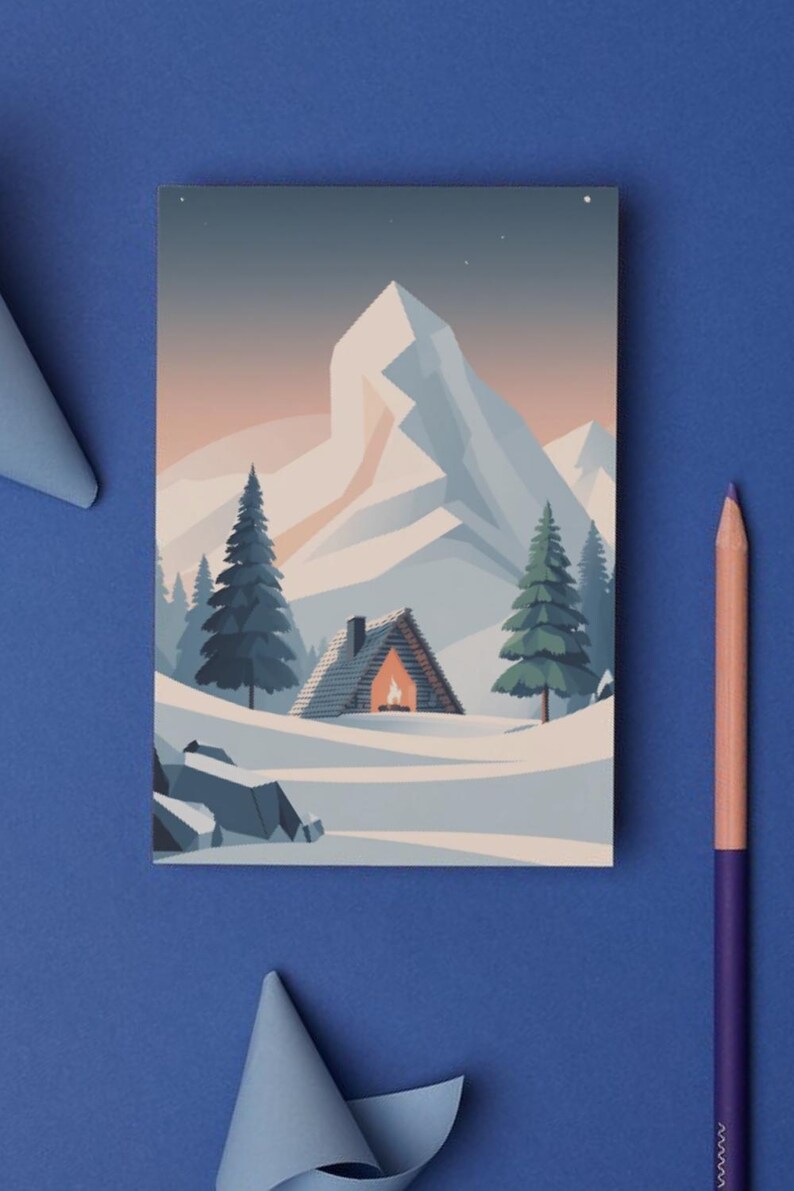 May include: A postcard depicting a winter scene with a snow-covered mountain and fir trees. A cabin with a lit fireplace is in the snow. The postcard is on a blue surface with a pencil and paper cutouts.
