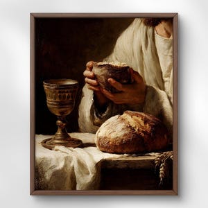 Puede incluir: Impresión enmarcada de una pintura religiosa. La obra de arte representa a una persona sosteniendo un cuenco de pan, con una hogaza de pan y un cáliz sobre una mesa. La pintura tiene una paleta de colores cálidos, con foco en el pan y el cáliz.