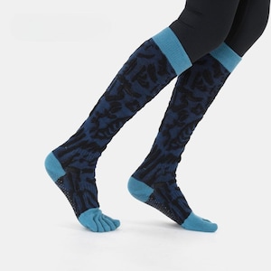 Könnte beinhalten: Kniestrümpfe mit blauem und schwarzem Muster, mit Zehentrennung. Die Socken haben einen hellblauen Bund und Zehenbereich. Getragen mit schwarzen Leggings, sind diese Socken auf Komfort und Halt ausgelegt.