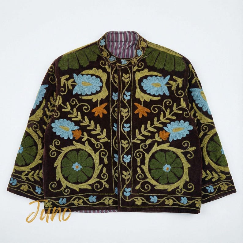May include: A brown jacket with intricate floral embroidery in shades of blue, green, and orange. The jacket features a mandarin collar and a striped lining. The embroidery creates a detailed pattern across the jacket's surface, showcasing a blend of colors and textures.