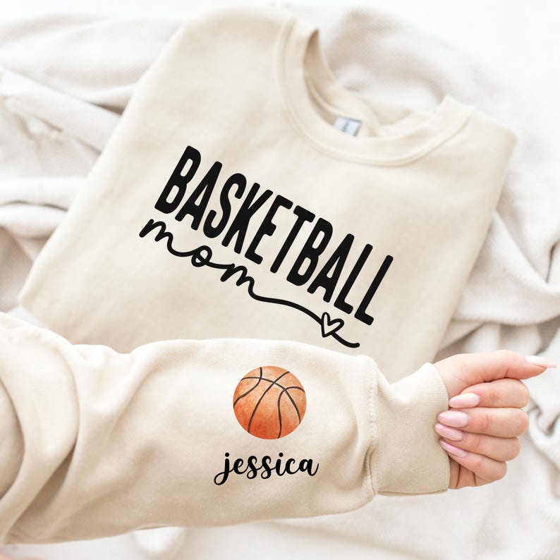 a person holding a basketball shirt with the word basketball on it