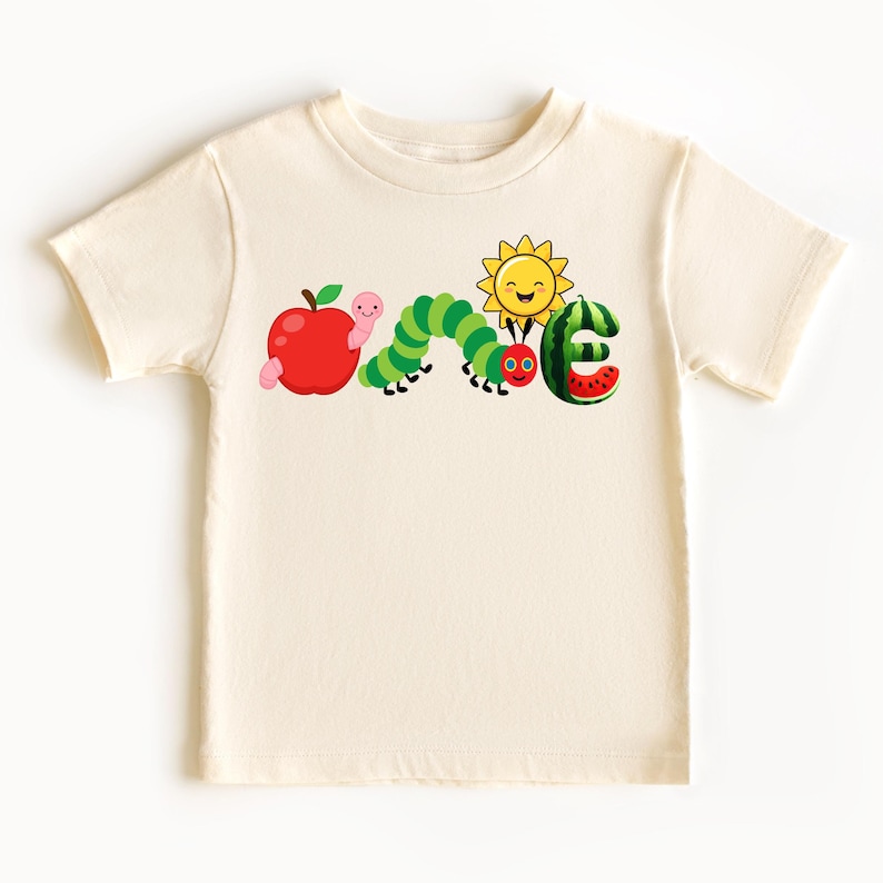a white t - shirt with a picture of a caterpillar and an apple