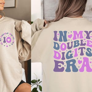 a woman wearing a sweatshirt that says in my double digits era
