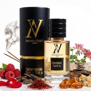 May include: Aroma Vault London perfume bottle with a black cap and gold accents. The bottle is labeled "Ombre Nova" and is accompanied by a black cylindrical box. The image includes raspberries, saffron, and amber stones, suggesting a fragrance theme.