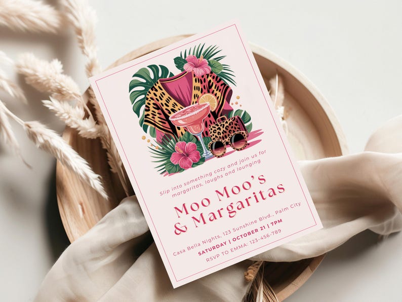 K&ouml;nnte beinhalten: Rosafarbene Einladungskarte mit dem Text "Moo Moo's & Margaritas" und Veranstaltungsdetails. Das Design umfasst eine Margarita, Sonnenbrillen mit Leopardenmuster und tropische Blumen. Die Karte liegt auf einem Holztablett.
