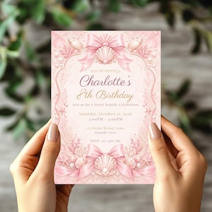 Può includere: Un biglietto d'invito rettangolare nei toni del rosa tenue con illustrazioni di conchiglie, coralli, perle e fiocchi di raso. Il testo recita: You're invited, Charlotte's 8th Birthday, Join us for a Sweet Seaside Celebration, Saturday, October 21, 2026, 2:00PM - 5:00PM, 123 Ocean Breeze Lane, Seaside Cove, RSVP: 123-456-789.