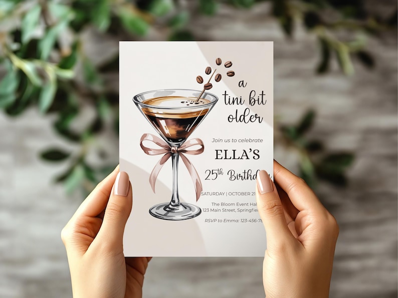 May include: A birthday invitation card featuring a watercolor illustration of a martini with coffee beans. The text reads "a tini bit older" and invites guests to celebrate Ella's 25th birthday. The card is held by a person.