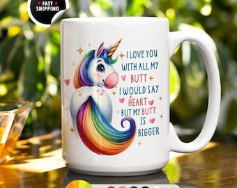 May include: White ceramic mug featuring a colorful unicorn illustration with a rainbow mane and tail. The mug has the text "I love you with all my butt, I would say heart, but my butt is bigger."