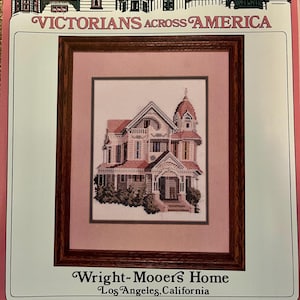 May include: A framed counted cross-stitch of the Wright-Mooers Home in Los Angeles, California. The Victorian house is rendered in shades of pink, brown, and white. The text "VICTORIANS ACROSS AMERICA" is at the top.