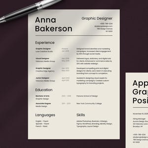 May include: A resume for a Graphic Designer named Anna Bakerson, with a pen in the upper left corner. The resume lists experience, education, languages, and skills. The resume also includes contact information.