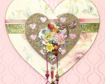 May include: A layered heart-shaped decorative piece with floral and dragonfly accents. The piece features a large heart with a floral pattern, a smaller heart with a brown background, and pink heart stickers. It is adorned with flowers and dangling beads.
