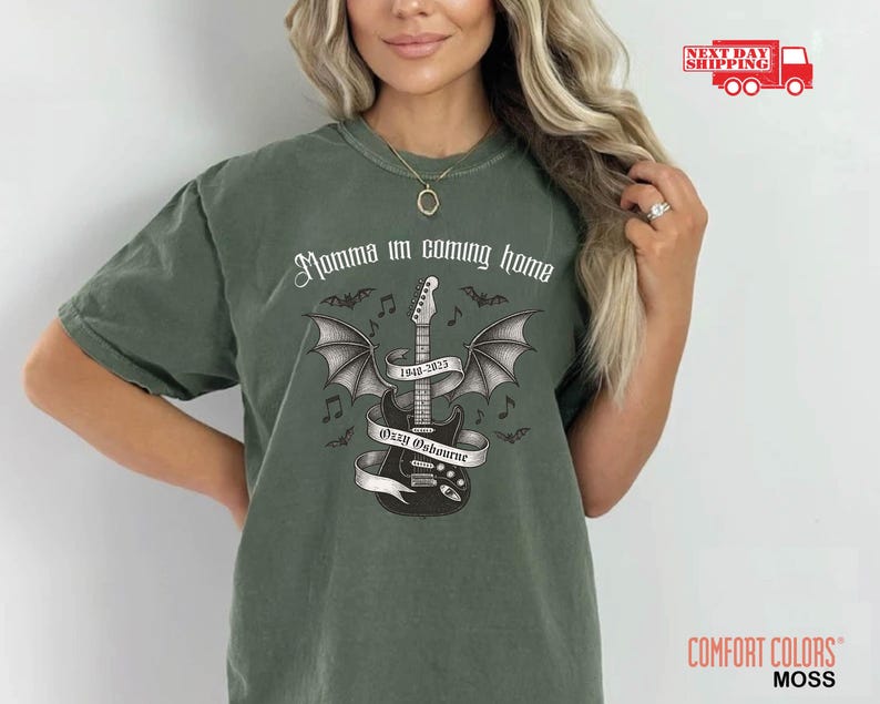 Puede incluir: Camiseta Comfort Colors verde musgo con un gr&aacute;fico de guitarra alada, el texto "Momma I'm coming home" y "Ozzy Osbourne 1948-2023". La camiseta tiene un corte relajado y est&aacute; hecha de material suave.