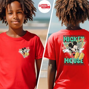 May include: Red t-shirt featuring Mickey Mouse. The front has a small graphic of Mickey in a triangle with a checkered background. The back of the shirt has a larger Mickey Mouse graphic with the words "Mickey Mouse" in a retro font.