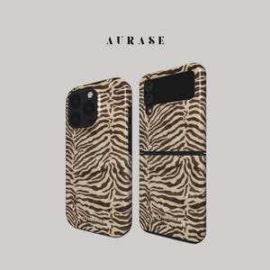 May include: Two phone cases with a zebra print design. One case is for a standard smartphone, and the other is a flip phone case. The cases are brown and tan with the brand name "AURASE" at the top.