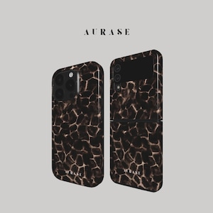 Op de afbeelding: Twee telefoonhoesjes met een bruine en zwarte giraffenprint. De hoes aan de linkerkant is voor een iPhone en de hoes aan de rechterkant is een flip-telefoonstijl. Het woord "AURASE" staat bovenaan.