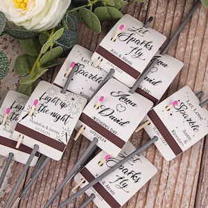 May include: A set of sparklers with personalised labels for weddings and other celebrations. The labels feature a variety of designs, including fireworks, hearts, and the words "Let Love Sparkle" and "Let Sparks Fly".