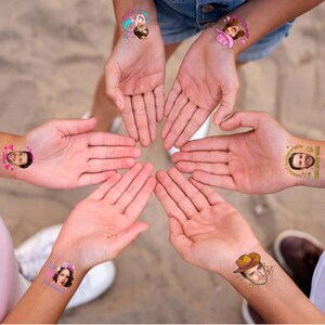 May include: A collection of temporary tattoos applied to wrists, featuring various colorful designs including cartoon characters, a pink cowboy hat, a brown cowboy hat, and custom portrait faces with text like "The Lucky Guy" and "She said yes".