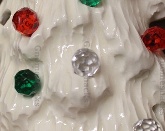 May include: White ceramic Christmas tree ornament with red, green, and clear glass beads. The beads are in a variety of shapes and sizes.