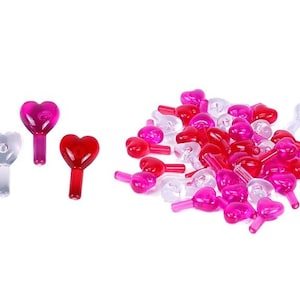 May include: Assortment of heart-shaped Christmas tree light bulbs in red, pink, and clear.