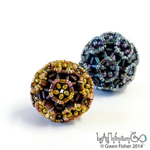 May include: Two beaded spheres, one in shades of brown and gold, the other in shades of blue and purple. The spheres are made of small beads woven together in a geometric pattern.