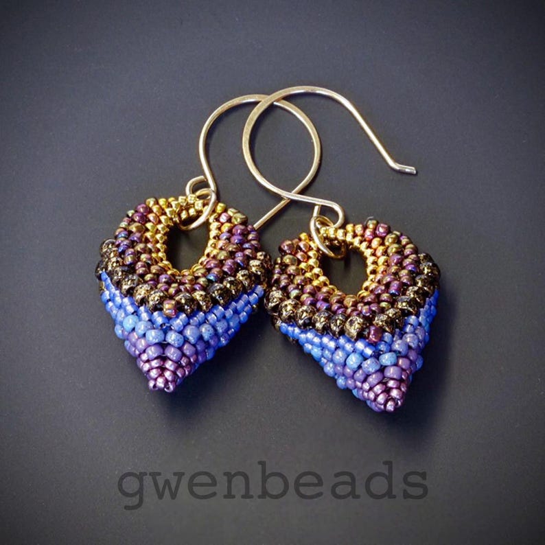 May include: A pair of gold-toned earrings with a teardrop shape. The earrings are made of small beads in shades of gold, brown, blue, and purple.