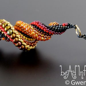 May include: A beaded bracelet with a spiral design in black, red, orange, and gold beads. The bracelet has a gold clasp.