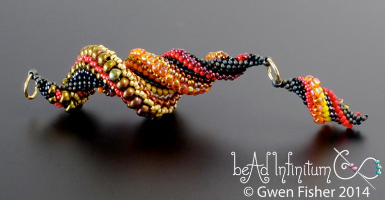 May include: A beaded bracelet with a spiral design in black, red, orange, and gold beads. The bracelet has a gold clasp.