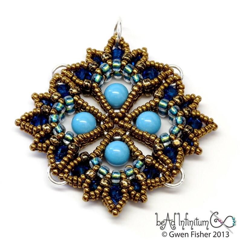 May include: A gold and blue beaded pendant with a snowflake design. The pendant features turquoise beads in the center and is surrounded by smaller gold and blue beads.