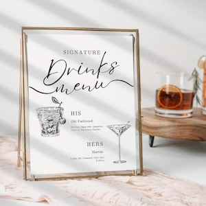 May include: A printable wedding drinks menu sign with a gold frame. The sign says "Signature Drinks Menu" and features illustrations of an Old Fashioned cocktail and a Martini.