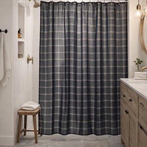 Puede incluir: Una cortina de ducha a cuadros gris oscuro en un baño moderno. La cortina presenta un patrón de cuadrícula con líneas blancas y marrón claro. El baño tiene un tocador de madera, un pequeño taburete de madera y una zona de ducha con azulejos blancos.