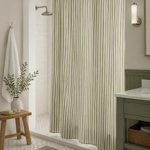May include: A shower curtain featuring a vertical striped pattern in alternating shades of sage green and white. The fabric hangs from a silver metal rod with circular rings, creating soft folds that extend from the top to the bottom edge.
