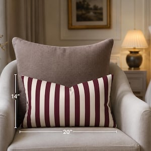 May include: A rectangular throw pillow featuring vertical stripes in deep burgundy and off-white. The pillow measures 14 inches in height and 20 inches in width, as indicated by the visible measurement lines on the front of the item.