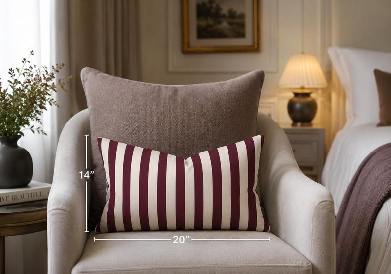 May include: A rectangular throw pillow featuring vertical stripes in deep burgundy and off-white. The pillow measures 14 inches in height and 20 inches in width, as indicated by the visible measurement lines on the front of the item.