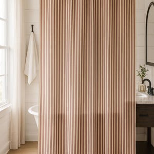 May include: A shower curtain featuring a vertical striped pattern in alternating shades of muted reddish-brown and cream. The curtain hangs from a black metal rod with integrated rings, displaying a consistent pleated drape across its full width.