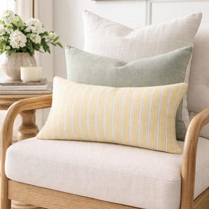 May include: A set of three ceramic mugs with a speckled, matte finish. The mugs are in shades of cream, light gray, and dark gray. Each mug has a simple, minimalist design, perfect for coffee or tea.