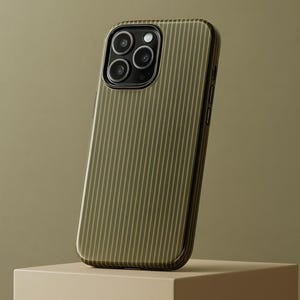 May include: Olive green phone case with vertical striped pattern. The case has a glossy finish and a black camera module. The phone case is displayed on a beige cube against a matching background.