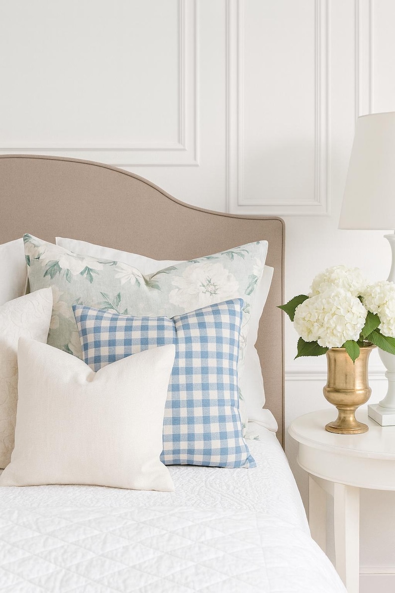 Feminine blue gingham pillow on a modern classic bedroom