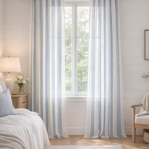 May include: Sheer, light blue and white striped curtains hang in front of a window. The curtains are hung on a dark brown rod. The room has white walls and a light-colored rug.
